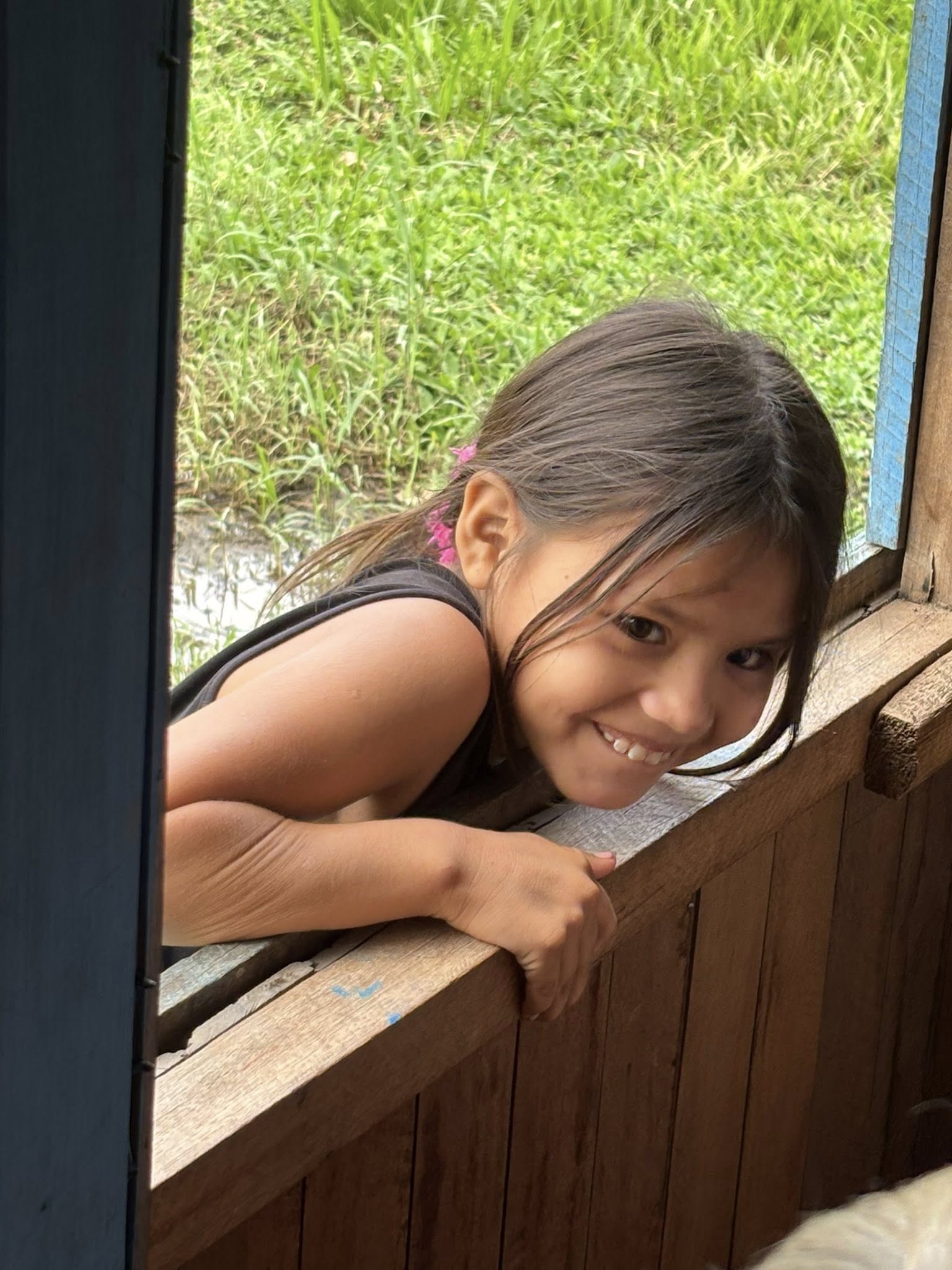 Young girl peeking through the window.