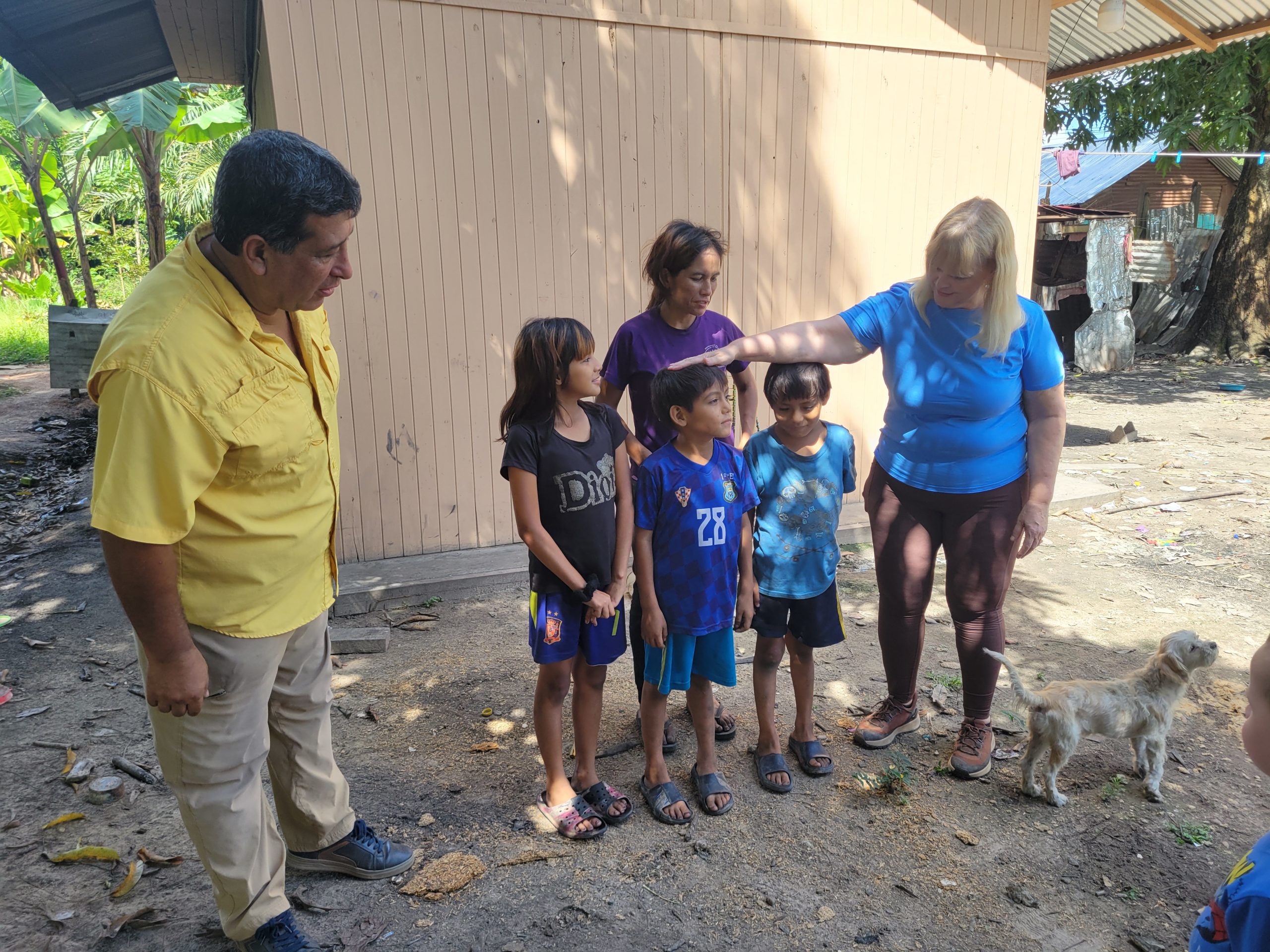 Milagro's family with home behind them.